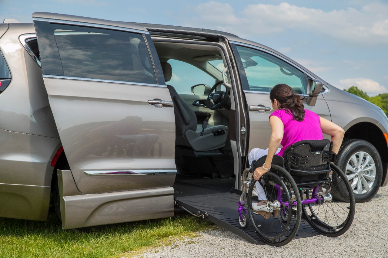 Woman in manual wheelchair acends the ramp in a BraunAbility Chrysler Pacifica Foldout 