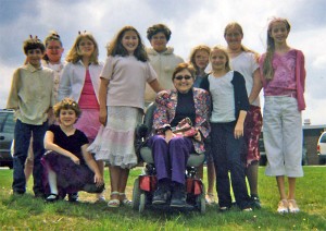 Lynn Will in a power chair is surrounded by her many grandkids on a spring day