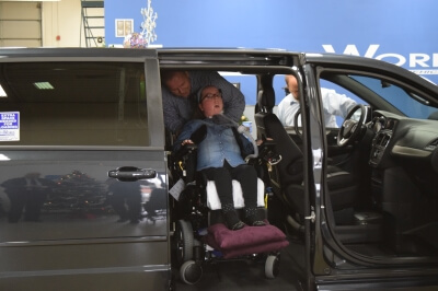 Lauren Gross exits a side-entry BraunAbility vehicle in a MobilityWorks dealership