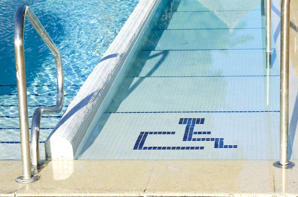 Access to swimming pool for handicap with handicapped symbol Access to swimming pool for handicap with handicapped symbol