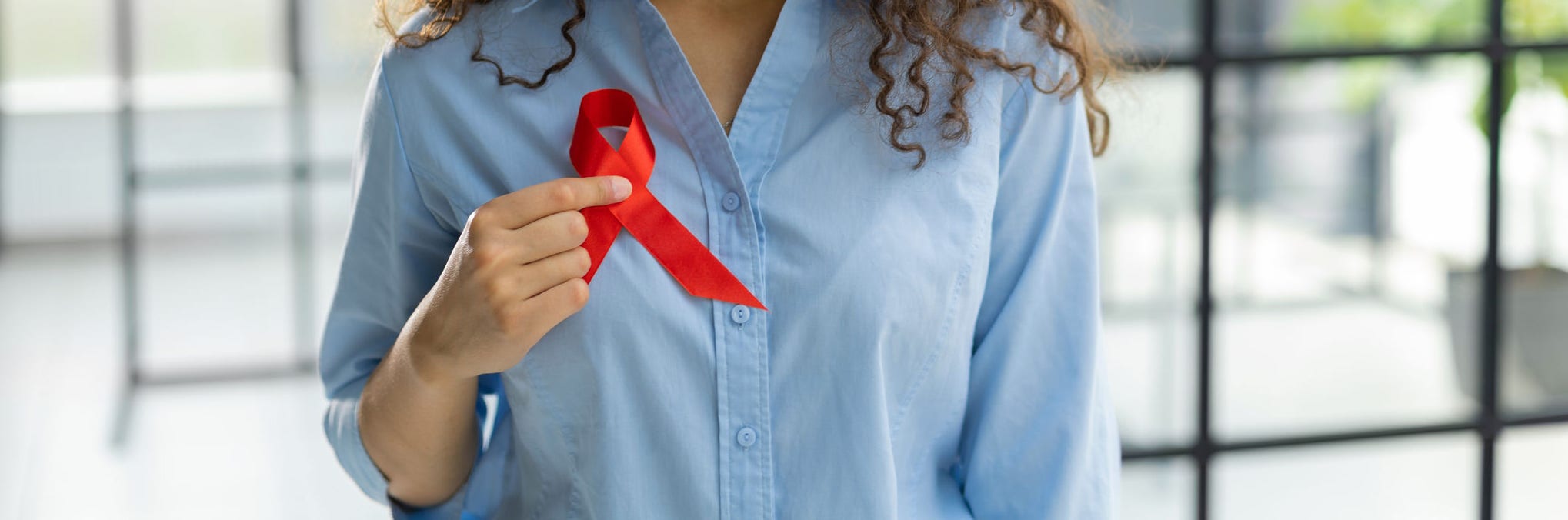 Woman holding red ribbon for december world aids day. Healthcare concept