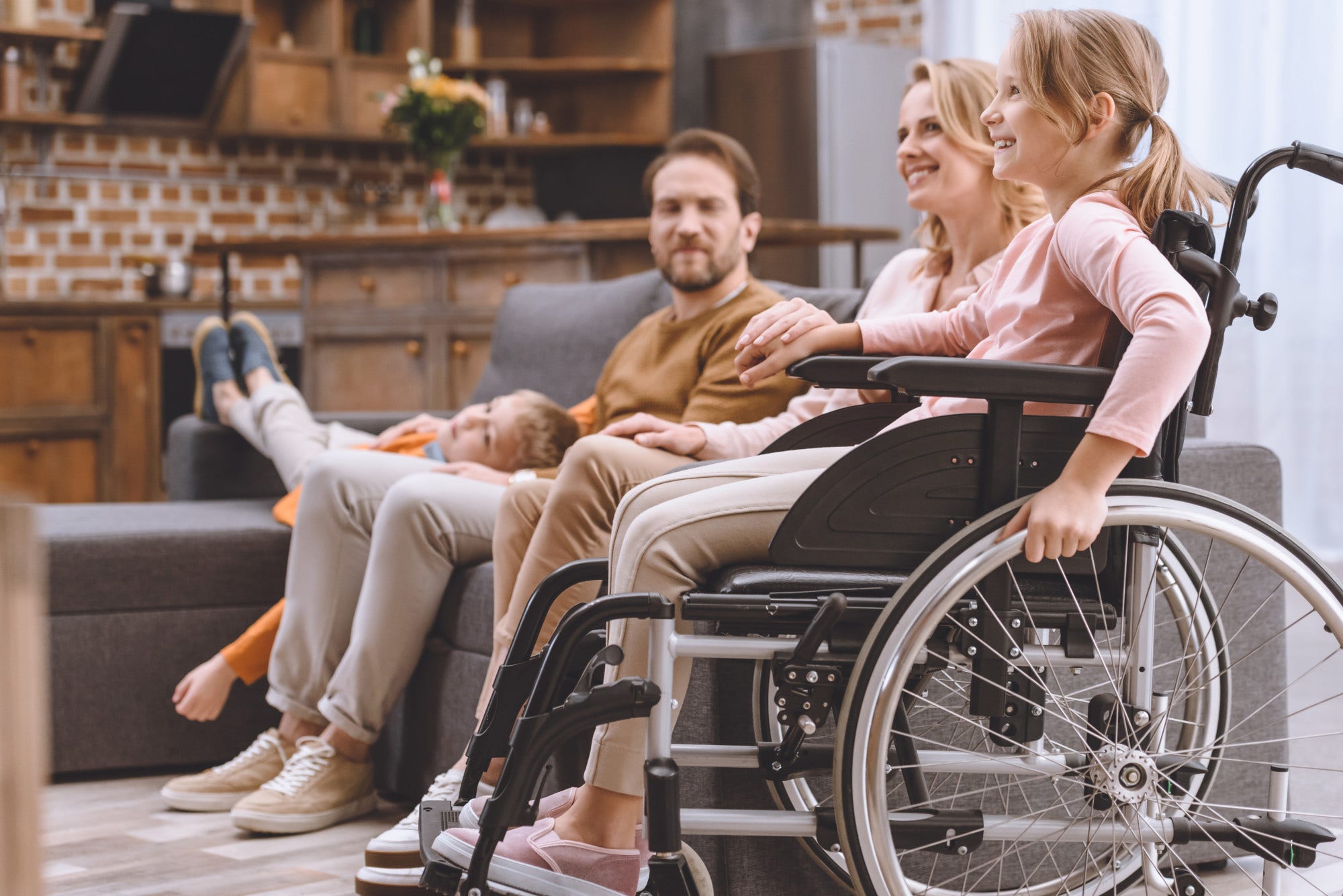 happy family with disabled little daughter in wheelchair spending time together at home happy family with disabled little daughter in wheelchair spending time together at home