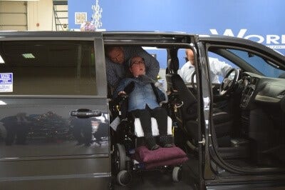 Lauren Gross exits a side-entry BraunAbility vehicle in a MobilityWorks dealership