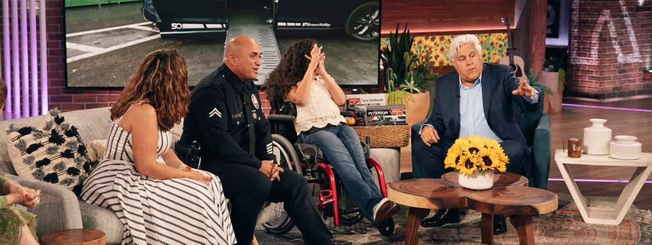The Arrue family learn from guest host Jay Leno that they’re actually on The Kelly Clarkson Show to receive a brand-new BraunAbility Pacifica. Jay Leno telling the Arrue Family on the Kelly Clarkson show that they are being given a brand new Chrysler Pacifica wheelchair van