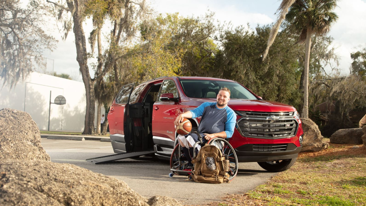 Man in a wheelchair infront of Wheelchair Van