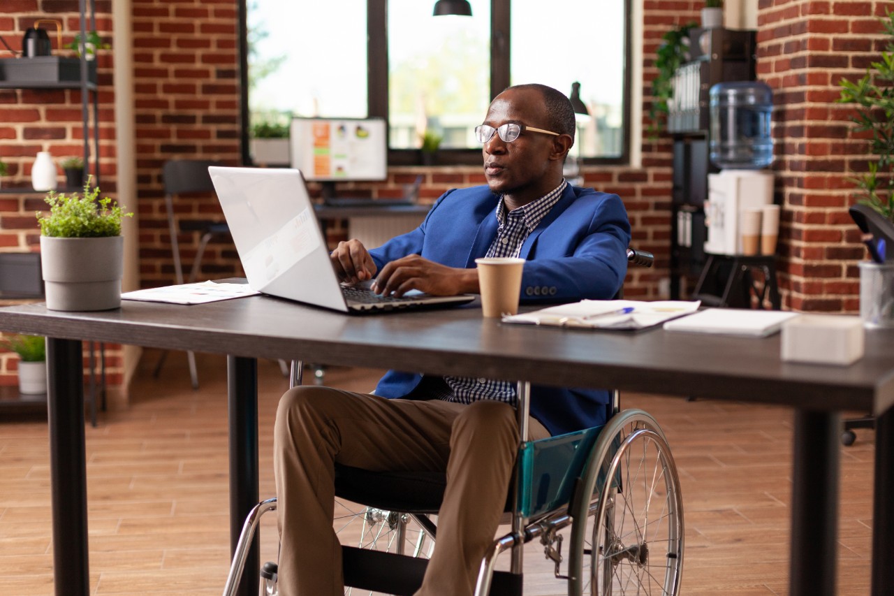 Man in a wheelchair using a labtop