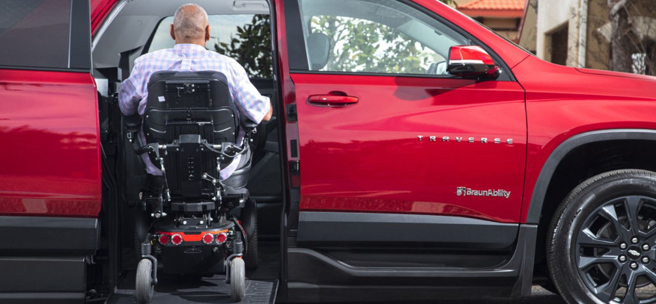 Man in a Electric Wheelchair going up a ramp into a Chevy Traverse WAV