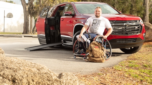 a veteran sitting next to his wheelchair suv chevy traverse