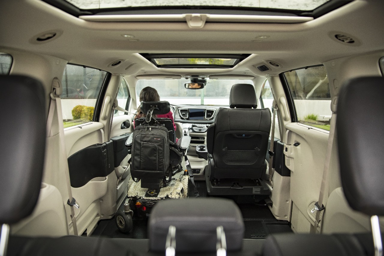 a gril driving a wheelchair van while in her power wheelchair