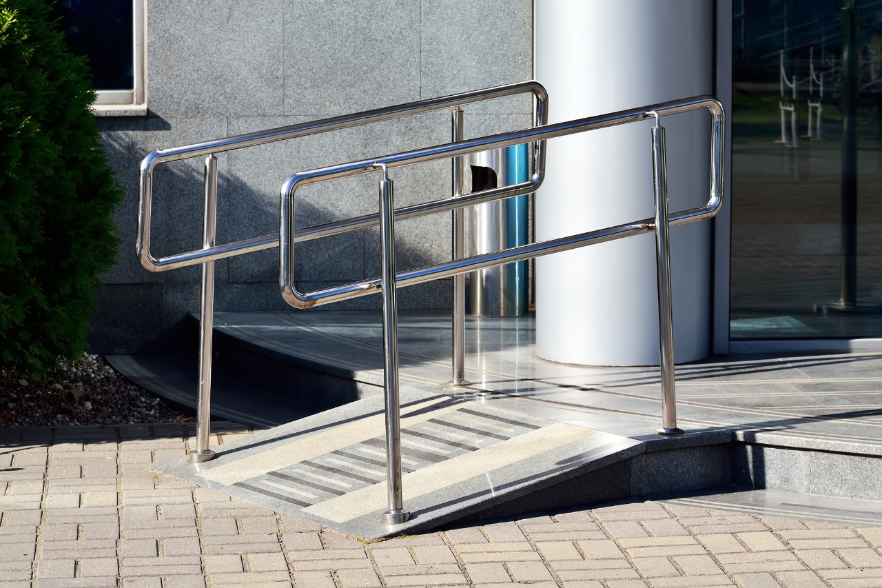 Ramp for wheelchair entry with metal handrails