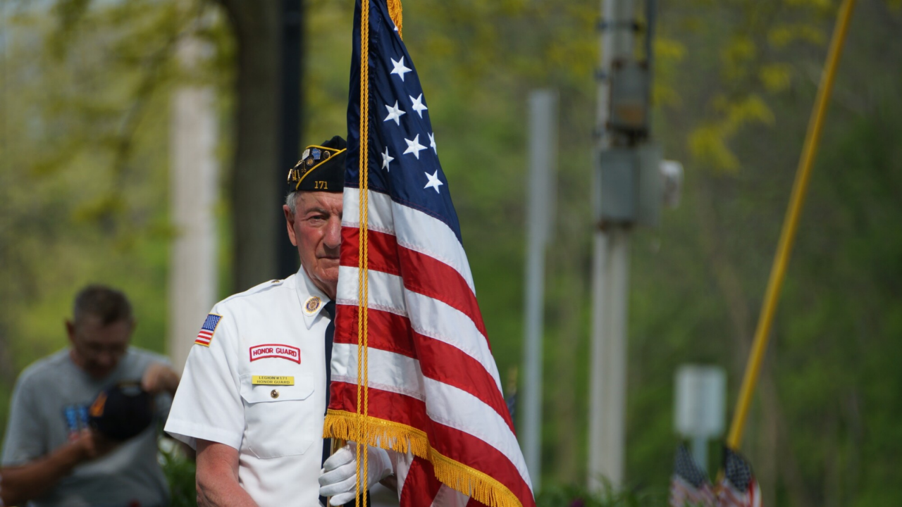 Man holding flag at memorial day ceremony