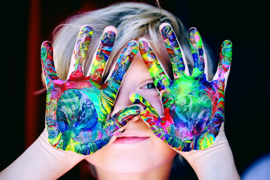 a child with many paint colors on the hands
