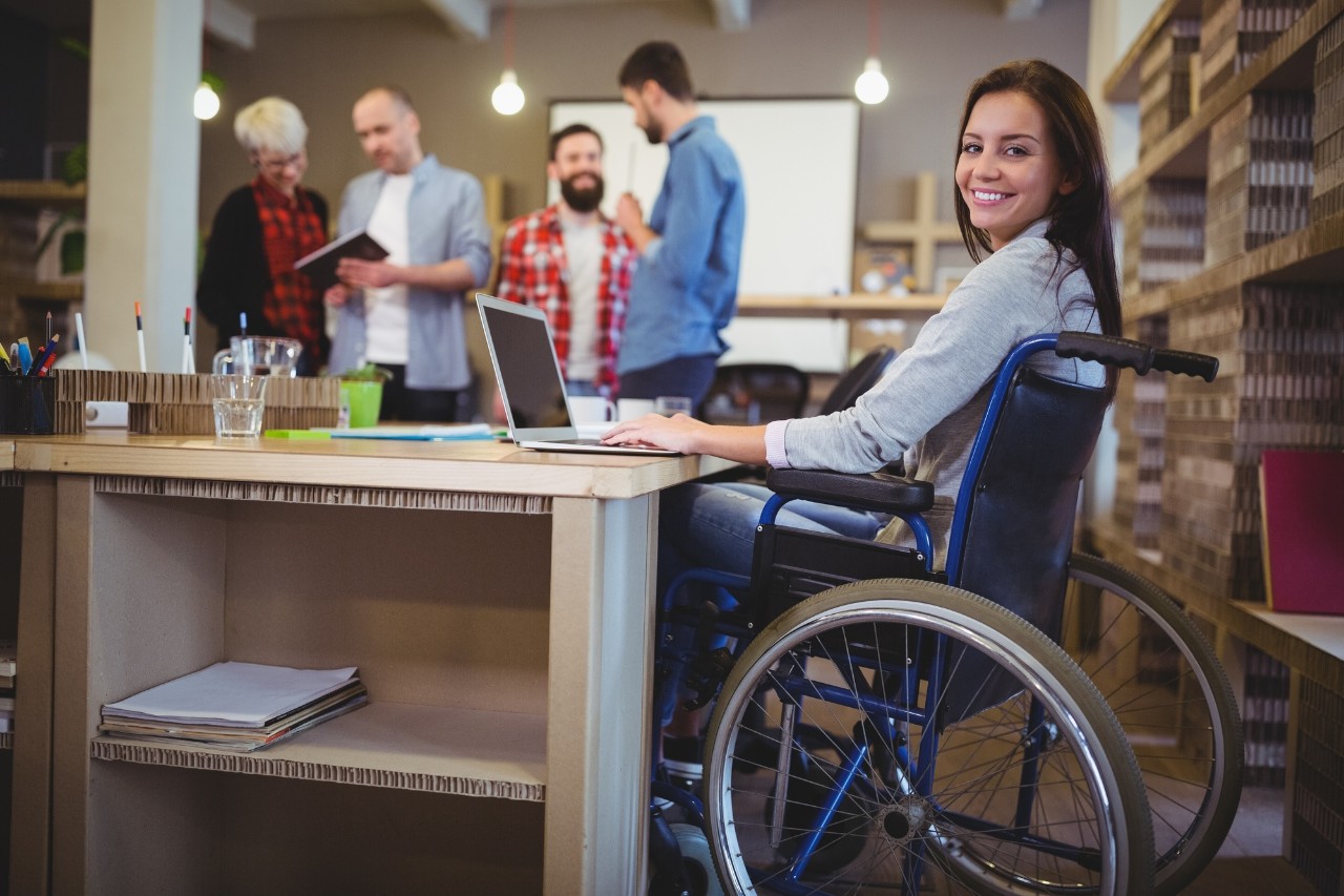 Confident disabled businesswoman using laptop in office