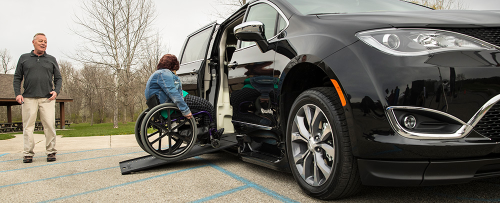 Lady in a wheelchair using a Ramp get into a Handicap Van