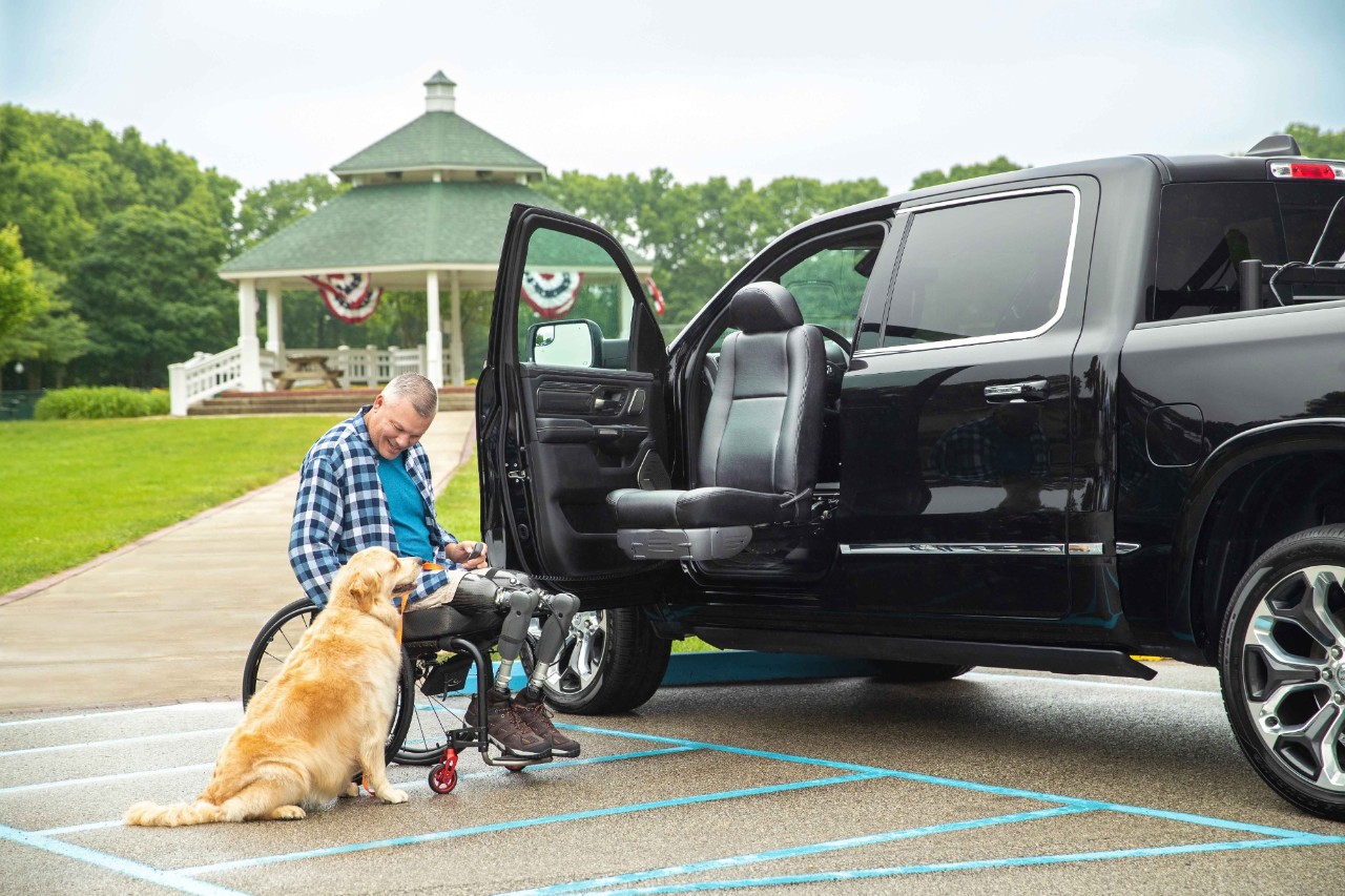 A man and his dog by his truck with a transfer seat
