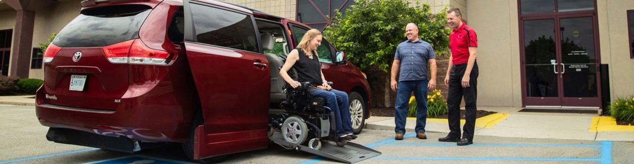 Woman in a Electric Wheelchair using a Ramp to get out of her Wheelchair Accessible Vehicle
