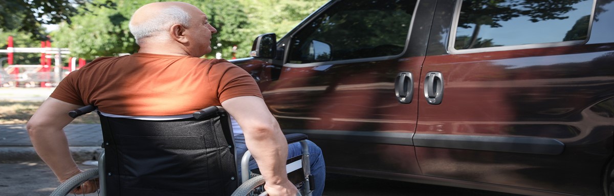 Man in wheelchair sitting outside of van