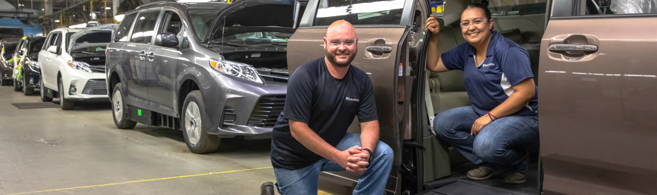 Manufacturing employees work on handicap accessible vehicle