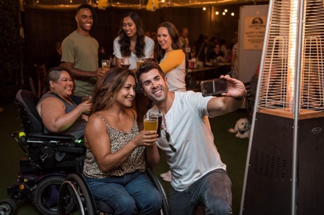 wheelchair users at a inclusive party taking a selfie while having fun