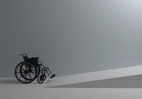 a wheelchair in a grey room getting ready to go up a wheelchair ramp a wheelchair in a grey room getting ready to go up a wheelchair ramp