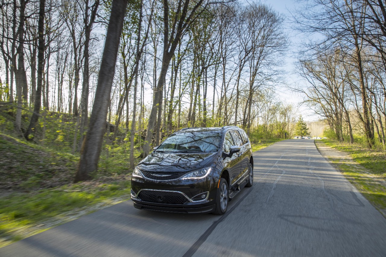 BraunAbility Chrysler Pacifica driving through a wooded road