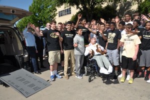 Colony High School students gather around Brian in a power wheelchair and wave