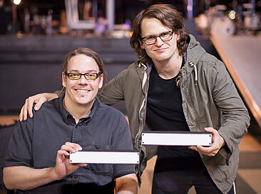 Jason Gerling and Gabriel Hagan hold lighted sensors that attach to their drumkits