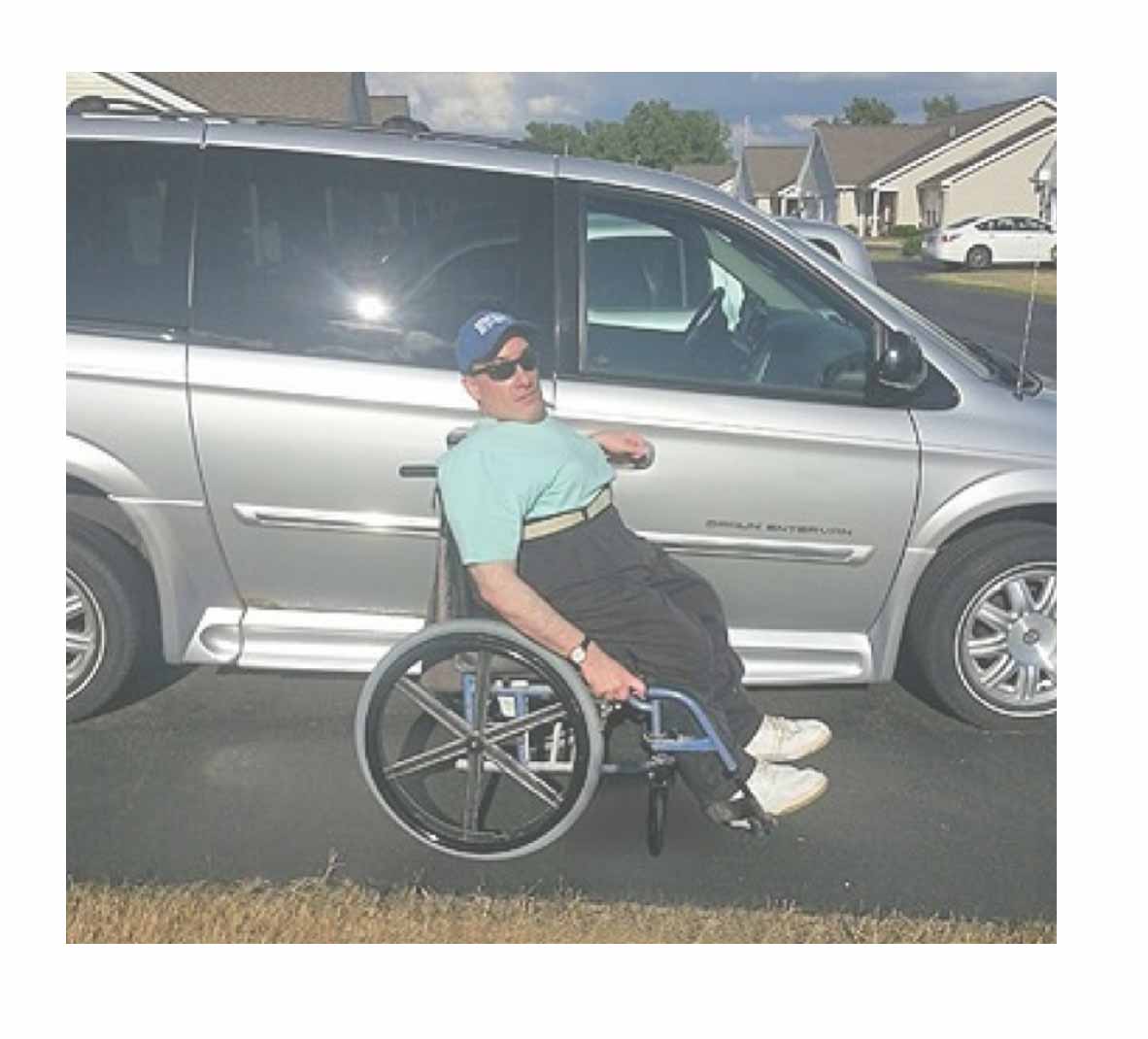 Tom Turner poses in front of his BraunAbility Entervan|Tom Turner, a longtime BraunAbility customer, at the racetrack