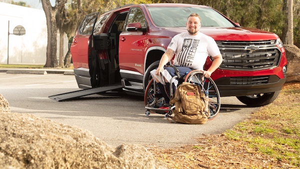 a veteran sitting next to his wheelchair suv chevy traverse a veteran sitting next to his wheelchair suv chevy traverse
