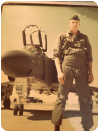 Ernie, a young airforce pilot, in uniform in front of his plane